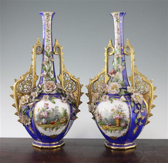 A pair of French jewelled and flower encrusted porcelain bottle vases